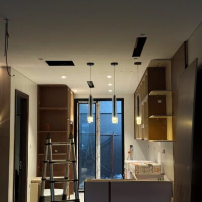 Đảo bếp với ba đèn thả và đèn âm trần đã lên đèn trong công trình HAT Lighting đang hoàn thiện