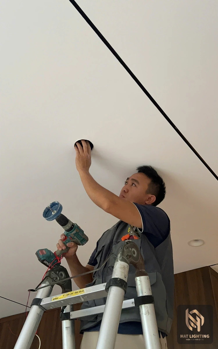 Kỹ thuật viên HAT Lighting khoét lỗ lắp đèn âm trần cạnh đường ray đèn